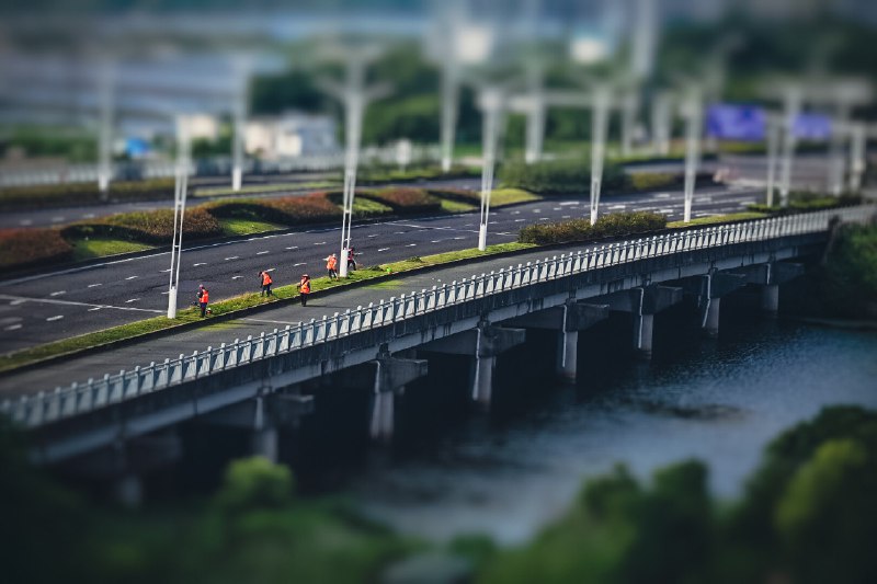 清晨的劳动者(The Morning Laborers)#UrbanLandscape #MorningMist #LaborOfLove #GoldenHourPhotography #TiltShiftEffect #StreetScene #CityLife #CloudyDawn #EverydayHeroes #PhotographyRevived2025.5.27 这是一个多云的薄雾清晨，夜间的阵雨随着微风匆忙离去，晨光缓缓穿透云层，射向湿气弥漫的大地，此时万物明朗可爱